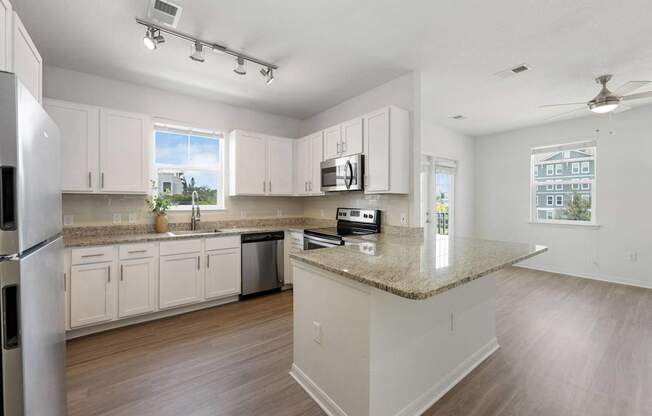 A kitchen with white cabinets and a granite countertop.