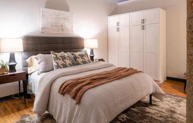 a bedroom with a large bed and white cabinets at The Draper, Missouri