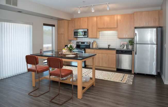 Kitchen with island, stainless steel appliances, granite countertops and large windows