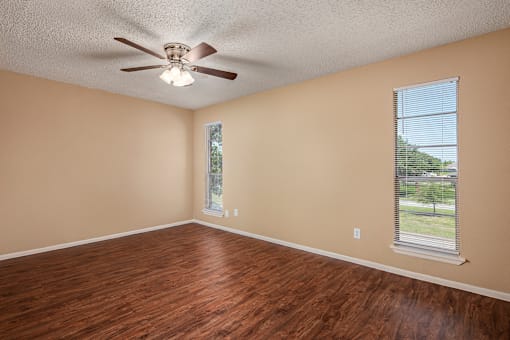 a bedroom with hardwood floors and a ceiling fan