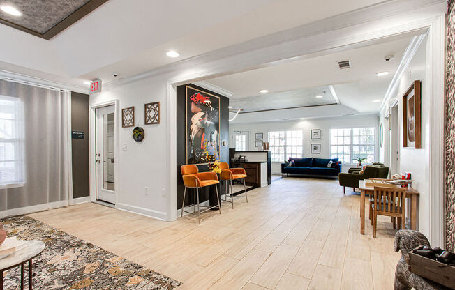 the living room and dining room of a house with white walls and wood floors