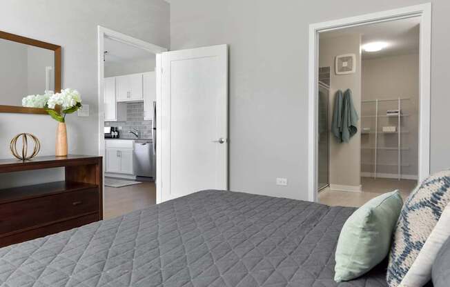 A bedroom with a bed, a dresser, and a mirror.
