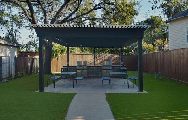 A patio with a table and chairs under a roof.