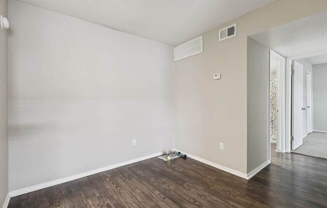 A room with wooden flooring and white walls.