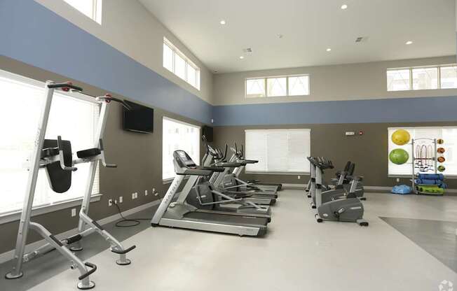 A gym with treadmills, elliptical machines, and other exercise equipment.