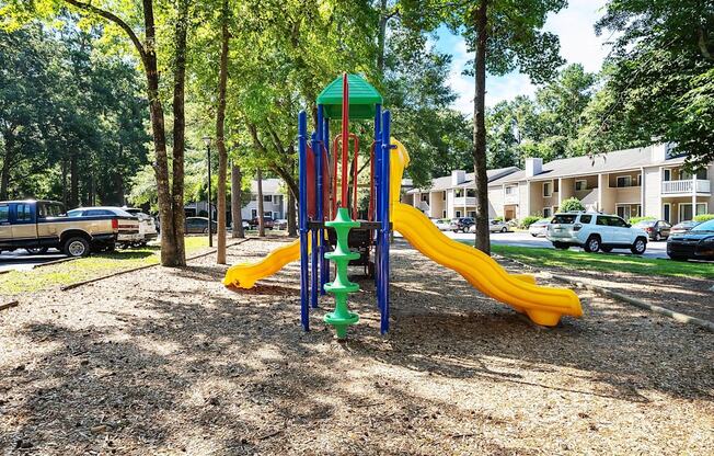 A playground with a yellow slide and a green top.