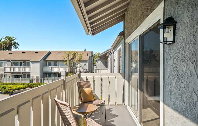 a terrace with chairs and a table and a view of a building and a