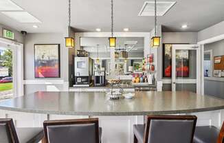 A kitchen with a table and chairs in front of it.