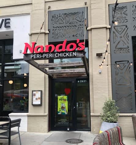 Nando's Peri-Peri Chicken restaurant with a black door and a sign above it. at Calvert House Apartments, Washington, Washington