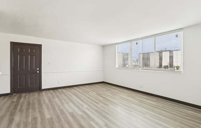 A room with a brown door and a window with blinds.