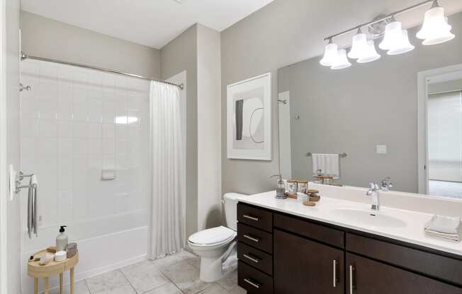 bathroom with dark wood vanity and tub shower