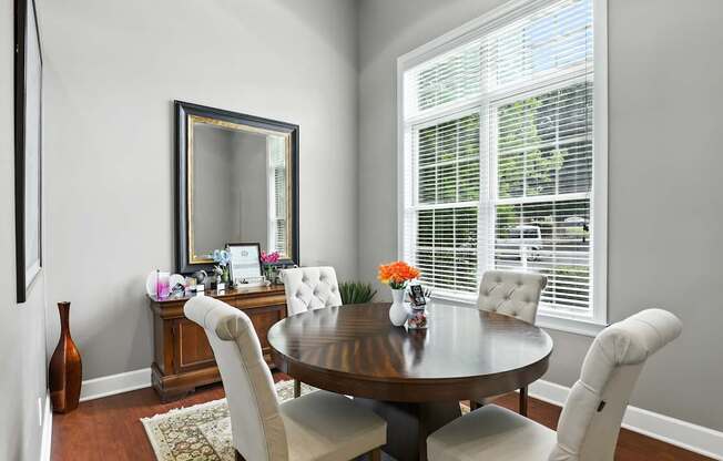 A dining room with a round table and chairs.