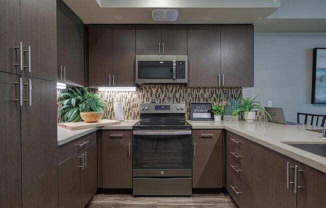 Cozy kitchen with dark cabinetry, tile backsplash, and an organized layout suited for everyday cooking.