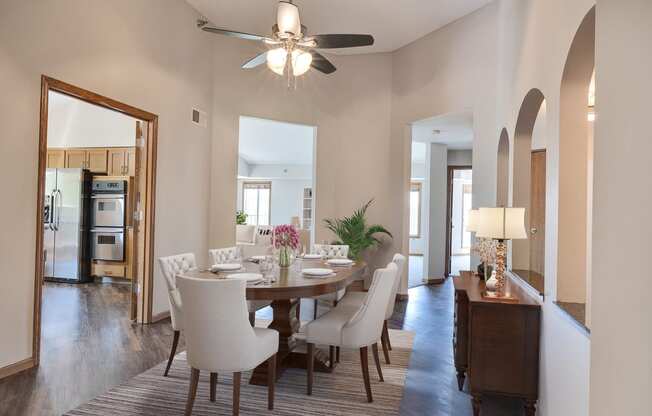 a dining room with a table and chairs and a ceiling fan