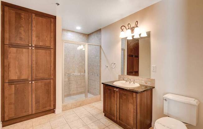 A bathroom with a toilet, sink, and shower.