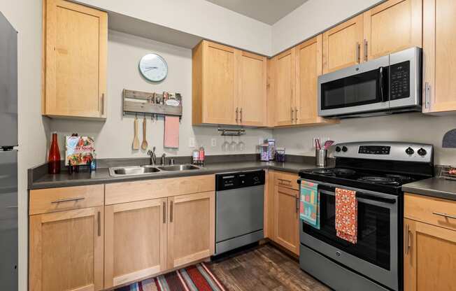 a kitchen with wooden cabinets and stainless steel appliances and a microwave