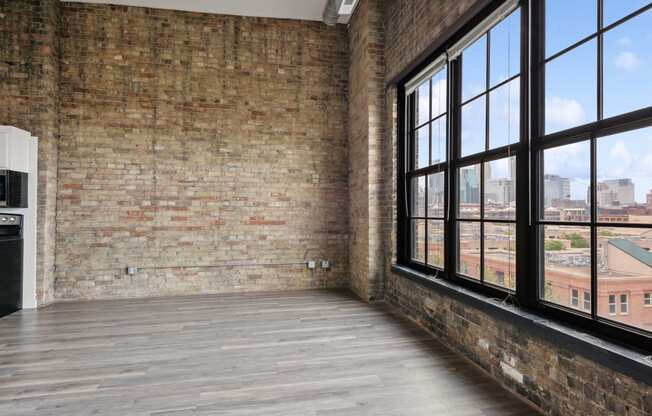 an empty room with large windows and a wooden floorat Gaar Scott Historic Lofts, Minnesota, 55401