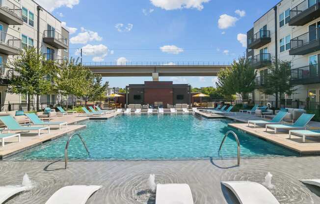 a swimming pool with lounge chairs and a bridge over it