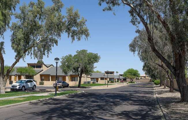 a street with houses and trees and a car on it