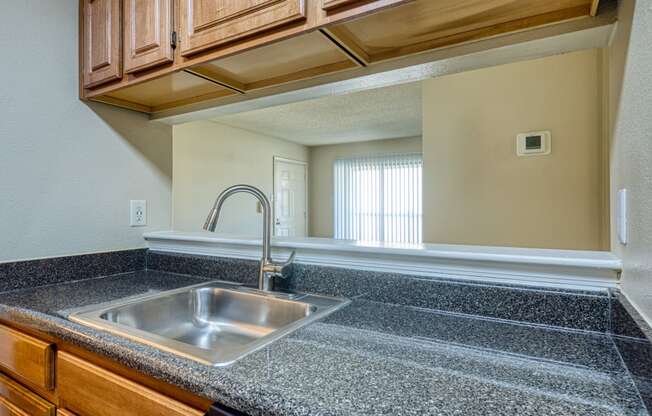 the kitchen has granite counter tops and a stainless steel sink