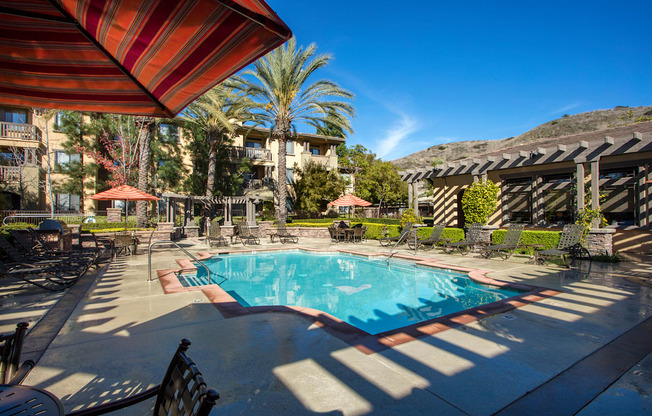 Apartments for Rent in Ladera Ranch, CA-55+ Remington at Ladera Ranch-Pool with Lounge Seating, Umbrellas, and Tables