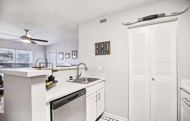 A kitchen with white cabinets and a black fridge.
