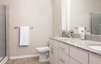A white toilet sits in a bathroom with a glass shower door.