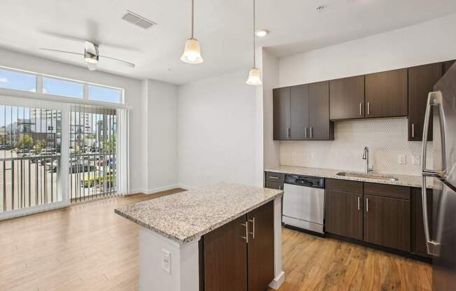 A kitchen with a granite countertop and stainless steel appliances.