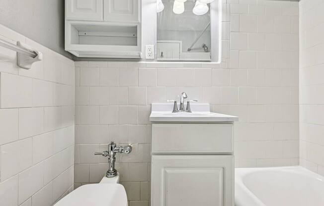A white bathroom with a toilet, sink, and tub.