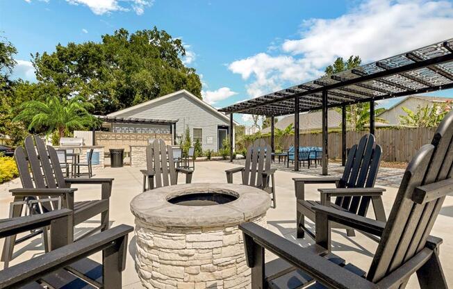 the fire pit is surrounded by wooden chairs and a pergola