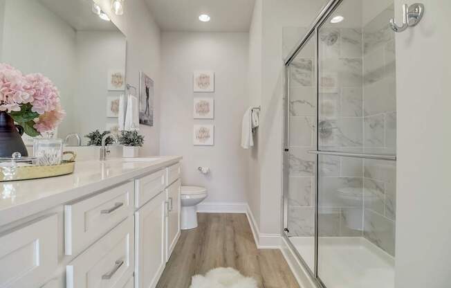 A white bathroom with a walk in shower.