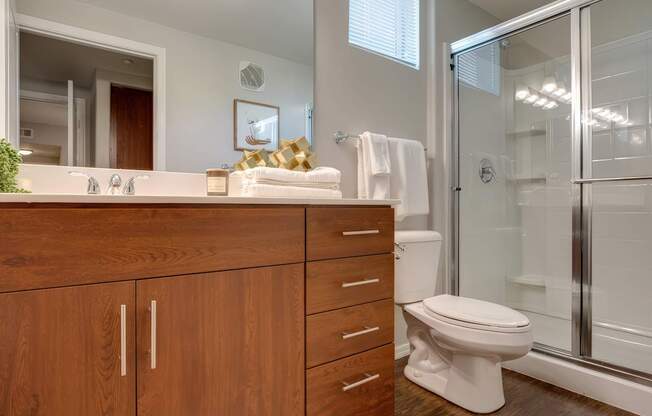 A bathroom with a toilet, sink, and mirror.