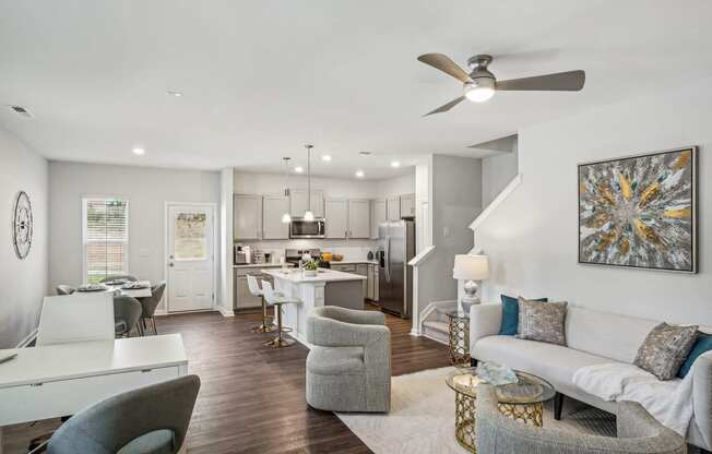 an open living room and kitchen with a ceiling fan