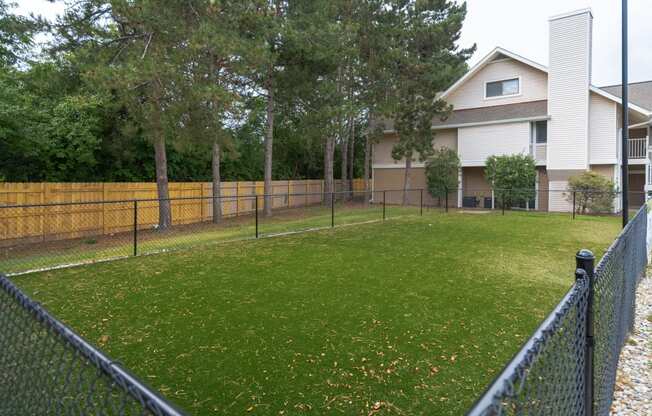 a fenced in yard with a house in the background