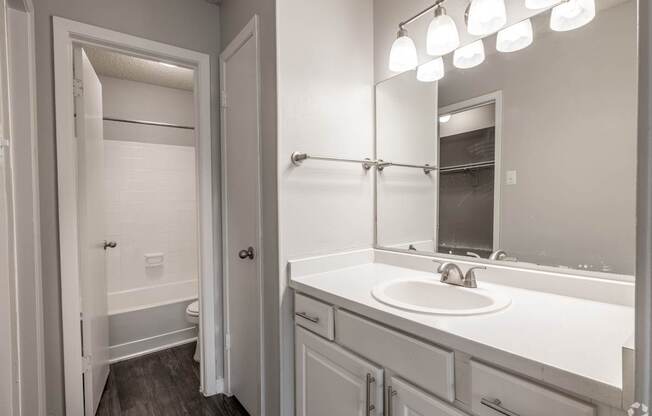 A bathroom with a white sink and a white toilet.