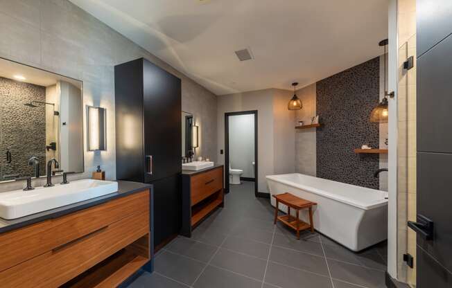 Apartments Near Woodfield Mall in Chicago, IL - 20 West - Spacious Bathroom with Dual Sink Vanities, a Large Tub, and a Toilet Room