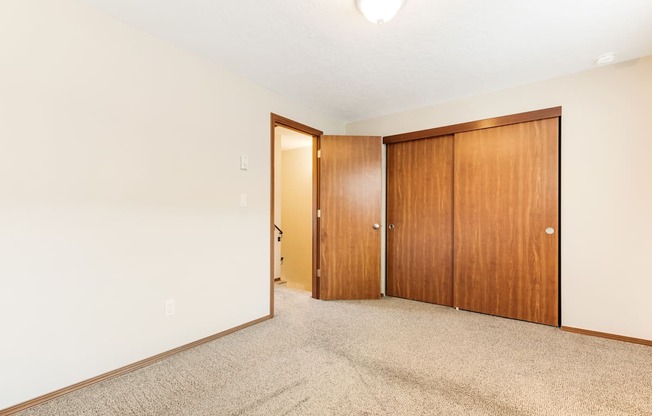 a bedroom with two doors and a carpeted floor