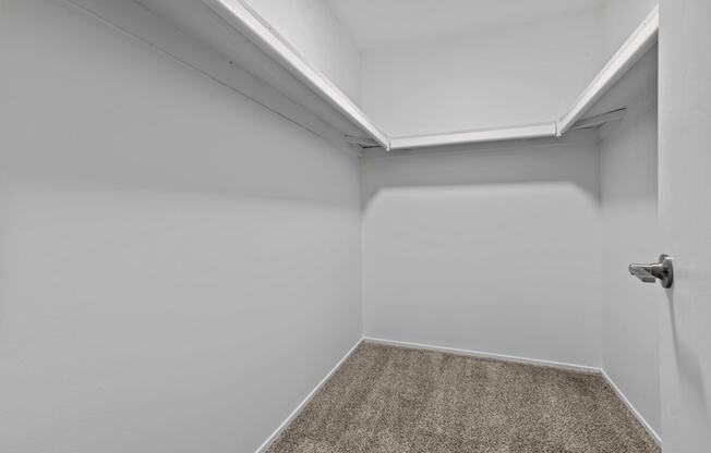 a small room with a carpeted floor and a white door