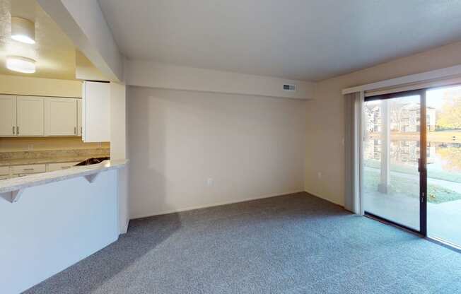 a living room with a kitchen and a sliding glass door