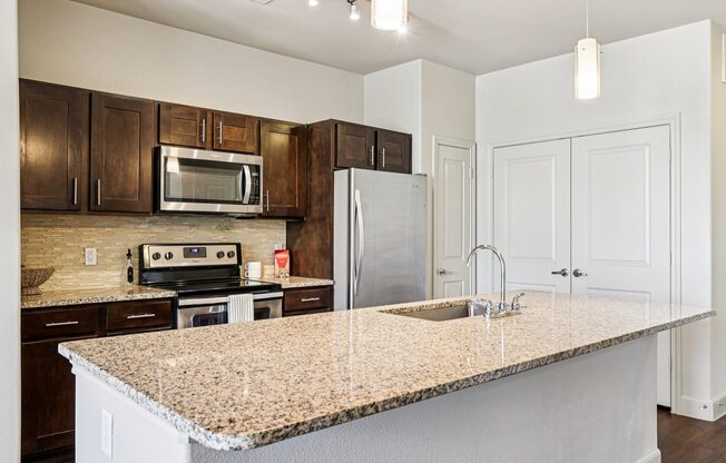 A kitchen with a granite countertop and white cabinets.