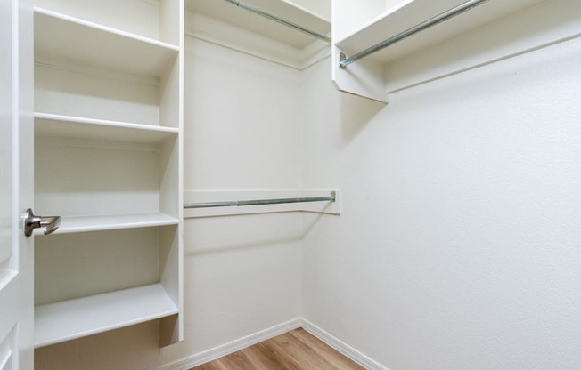 a walk in closet with shelves and a door