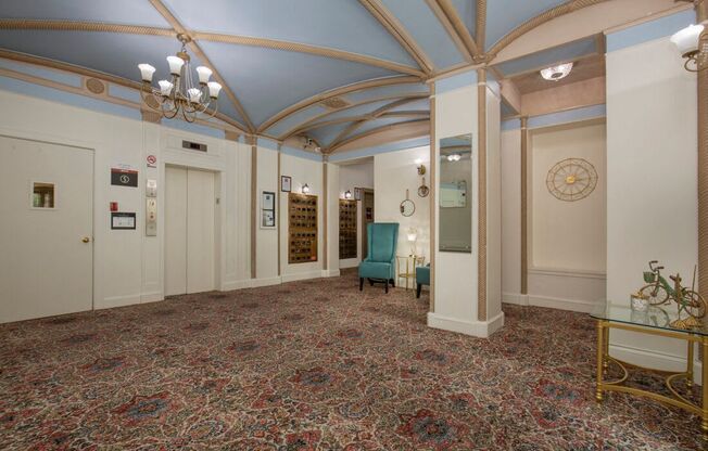 Lobby View of Pattered Carpeting, Blue Painted Ceiling with Detailed Gold Accent Pieces, and Large Chandeliers at Stockbridge Apartment Homes, Seattle