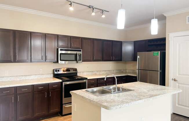 a kitchen with dark wood cabinets and white countertops