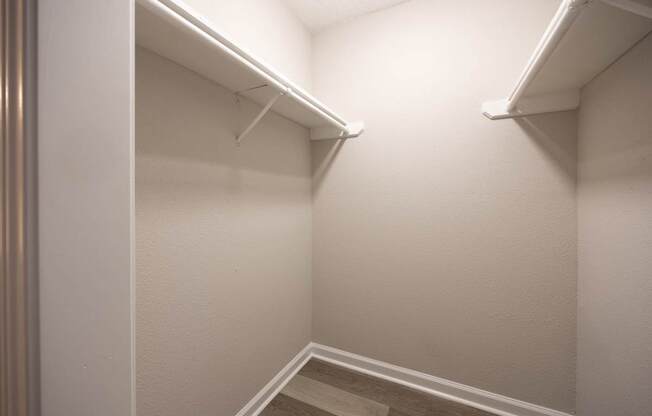 A white closet with a stairway leading to the second floor.