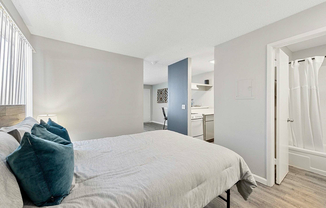 Experience modern comfort in this cozy bedroom with seamless access to the kitchen.