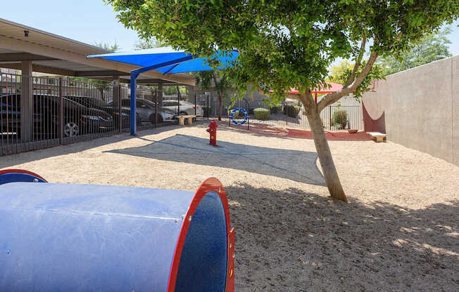 A playground with a blue slide and a red fire hydrant.