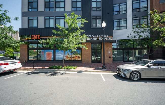 A car is parked in front of a building with a sign that says Tropical Cafe.