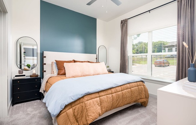 a bedroom with a bed and a dresser with a mirror