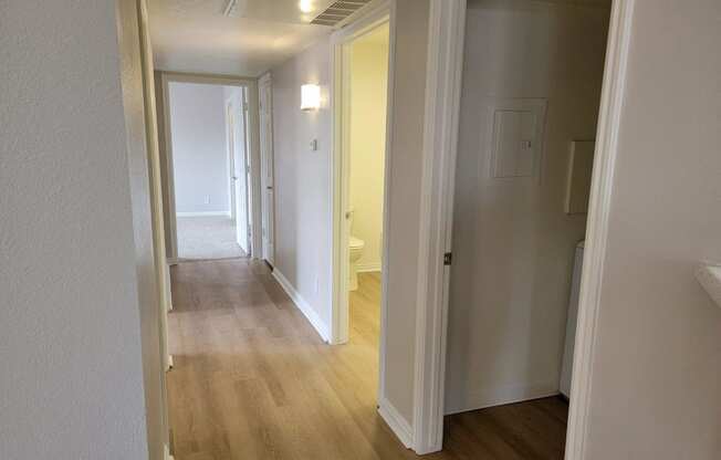 a passageway between two bedrooms and a hallway with a door to a bathroom