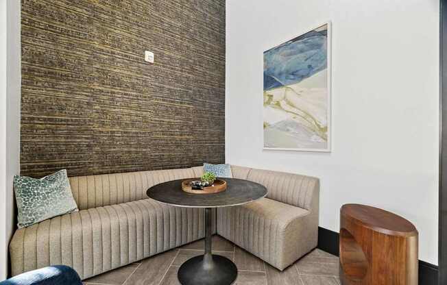 A round table with a plant on it sits between two couches in a room.